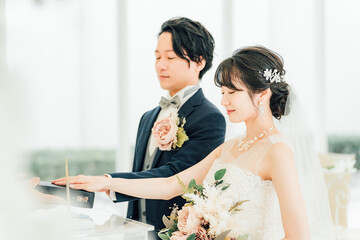 結婚式で聖書に手を重ねて宣誓・誓う新郎新婦
