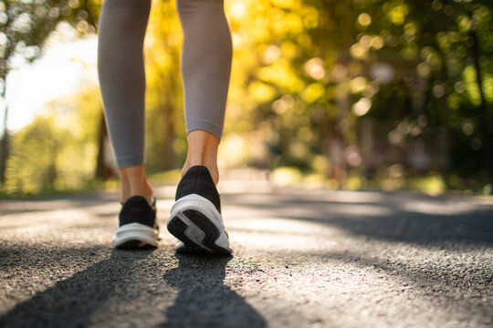 Active woman jogging walking outdoors in sunlight