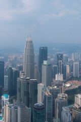Fototapeta na wymiar From an aerial perspective, Kuala Lumpur showcases its iconic Petronas Towers, bustling streets, parks, and a fusion of modern architecture and tropical greenery