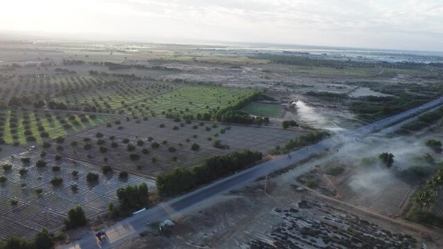 Aerial view of cars and bikers on a highway in the middle of farm field landscape in Balochistan