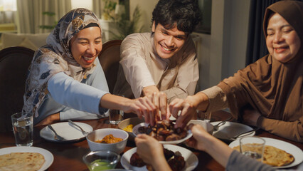 Eid Mubarak Muslim Asia family have Iftar dinner eat dates fruit to break feast. Eat traditional...