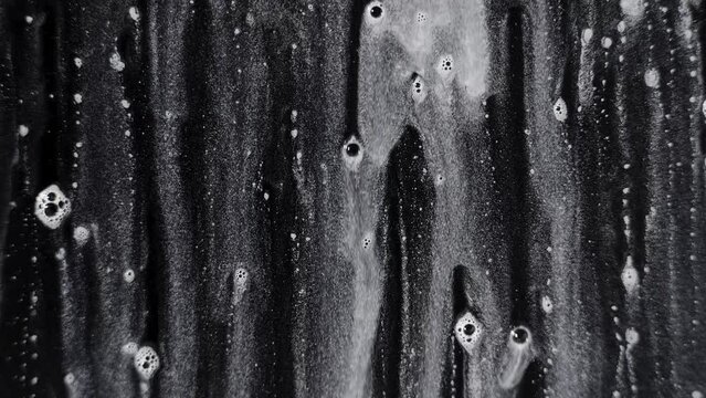 Foam streaming down on a plane surface on a black background 