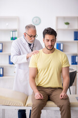 Fototapeta premium Young male patient visiting old male doctor