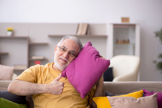 Old man with many pillows at home