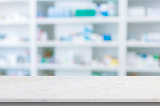 Empty white counter with pharmacy drugstore shelves blurred background