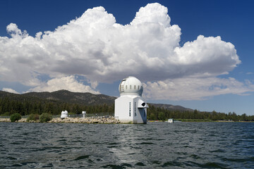 The Solar Observatory in Big Bear Lake, California, shown on a sunny afternoon with big, puffy clouds.