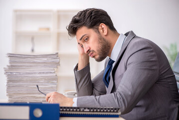 Fototapeta premium Young male employee and too much work in the office