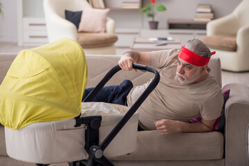 Old man looking after newborn at home
