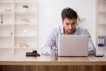 Young male employee working in the office