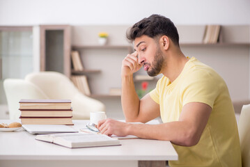 Naklejka premium Young male student studying at home
