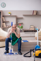 Old male contractor cleaning the house