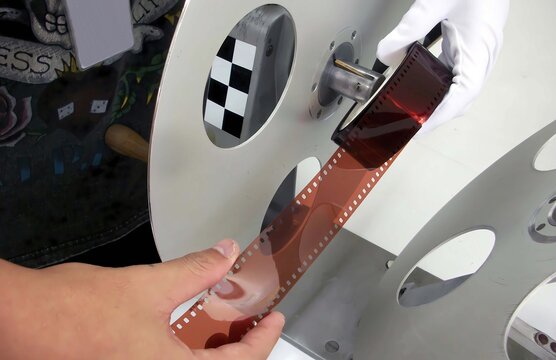 A staft was  inspection a negative film 35mm for QC to standard.