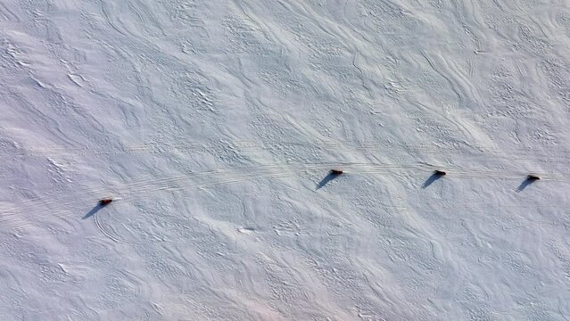 Aerial top view over people riding snowmobiles on the frozen ground of Myrdalsjokull glacier in Iceland