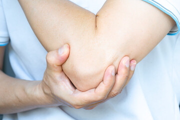 man touching the elbow with elbow pain And he relieves pain with massage. Health and healing concept