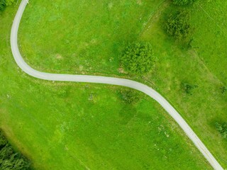 Aerial view of countryside road through fields in rural area in Switzerland.	