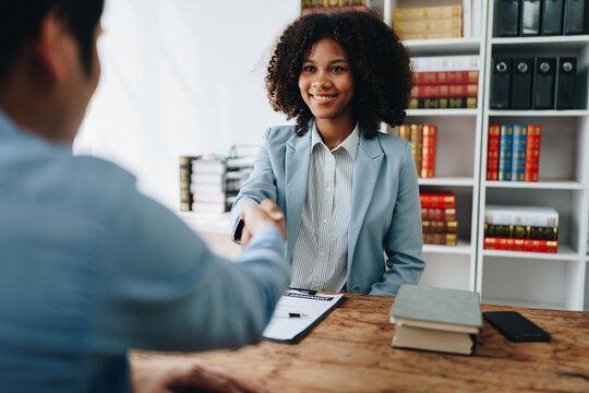Law, consultation, agreement, contract, lawyer or attorney shakes hands to agree on the client's offer to be hired to fight the parties in court.
