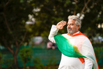 Indian man in traditional wear and saluting.