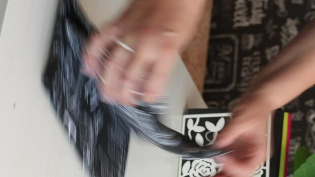A woman reviews a kitchen towel. He takes it out of the box and puts it on the table. vertical video. Close-up.
