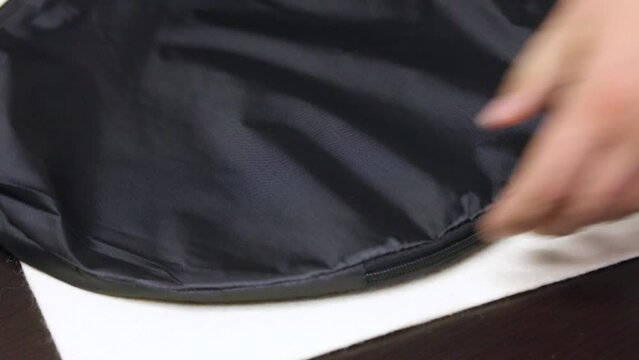 A man unpacks a package. Gray card for setting the white balance when shooting. In a case. Close up.