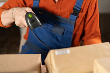 Scanning barcode on delivery parcel. Worker hands scan barcode of cardboard packages. Man in factory warehouse scanning labels on the boxes with barcode scanner.