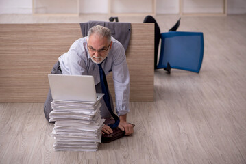 Fototapeta premium Old male employee and too much work in the office