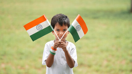 Cute little boy holding Indian flag in his hands and smiling. Celebrating Independence day or...