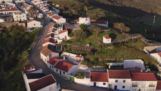 Wide shot of traditional Portuguese windmill at Odeceixe during sunrise, aerial