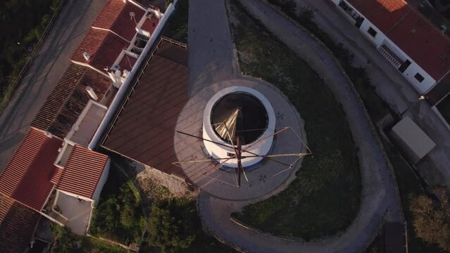 Reveal shot of old white windmill at Odeceixe Portugal during sunrise, aerial