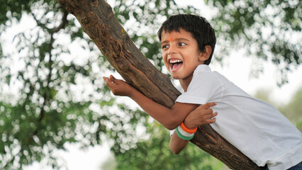 Cute little boy holding Indian flag in his hands and smiling. Celebrating Independence day or...