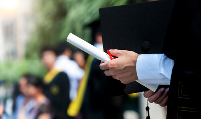 Graduating student holding their diploma proudly