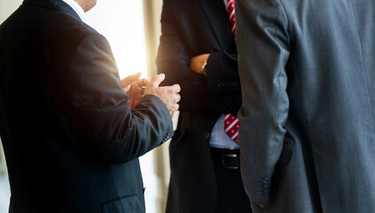 Three businessmen standing together communicating