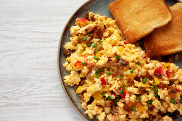 Homemade Fiesta Scrambled Eggs with Peppers and Toast on a Plate, top view. Flat lay, overhead, from above. Copy space.