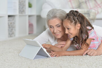 girl with grandmother using tablet