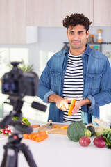 man filming himself preparing vegetables for a blog