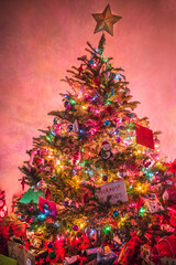 Vibrant red, glowing Christmas tree adorned with colorful ornaments