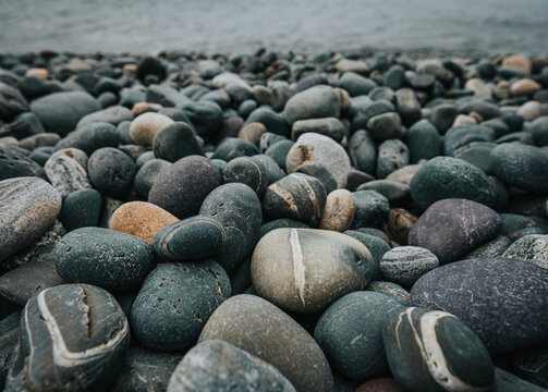 Close up of colorful smooth rocks on beach in Newfoundland, Canada. - Powered by Adobe