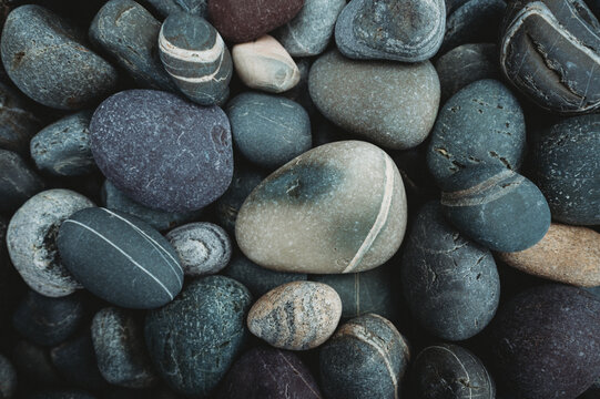 Close up of colorful smooth rocks on beach in Newfoundland, Canada.