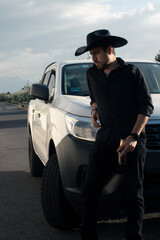 black hat cowboy on his white pickup truck