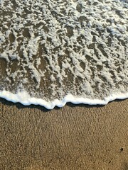 Wave of Water Covering Sand