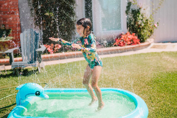 Toddler Girl Playing in Yard with Sprinkler