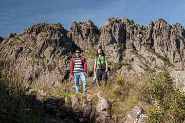 Fototapeta premium Beautiful view to couple of friends hiking on altitude fields