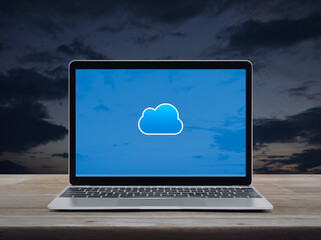 Cloud computing icon on modern laptop computer monitor screen on wooden table over sunset sky, Technology cloud computing concept