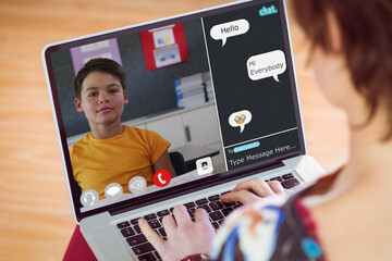 Caucasian teacher chatting and teaching boy over video call on laptop from home