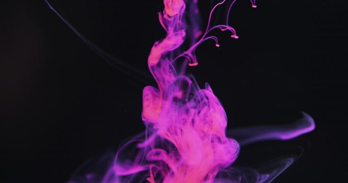 Slow motion video of purple watercolor ink mixing in water against black background