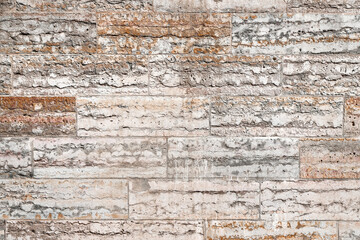 Texture of an old pink stone wall made of limestone blocks as an architectural background
