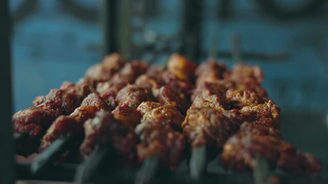 A close-up of meat skewers or kabob skewers in a metal tray at a roadside shop