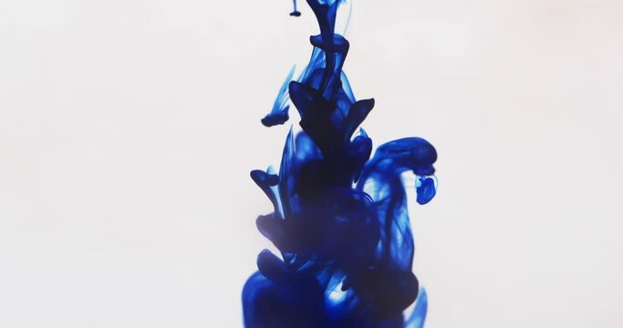 Slow motion video of blue watercolor ink mixing in water against grey background