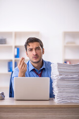 Young male employee and too much work in the office