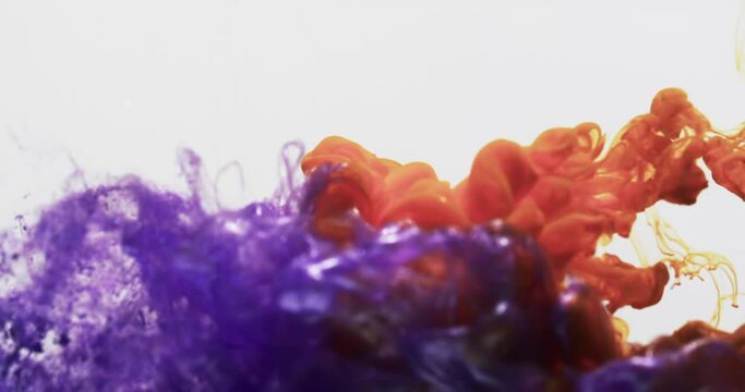 Slow motion video of purple and orange watercolor ink mixed in water against grey background