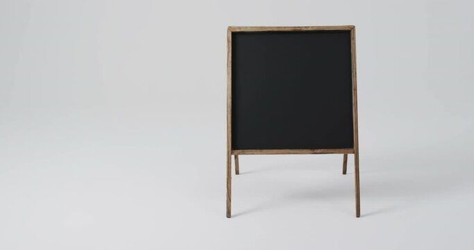 Video of blackboard sign on wooden stand with copy space on white background